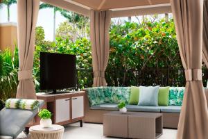 a living room with a couch and a tv at The Ritz-Carlton Naples in Naples