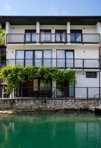 a building with a balcony next to a body of water at Vila Lago Verde in Zvornik
