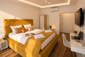 a bedroom with a large bed with a laptop on it at Vila Lago Verde in Zvornik