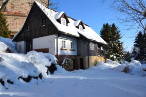 ein schneebedecktes Haus vor der Tür in der Unterkunft Chalupa Jana in Nová Paka