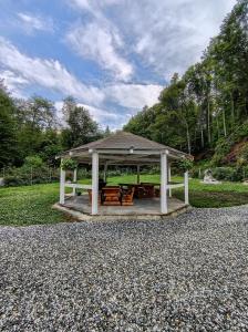 a gazebo with chairs and tables in a park at Cabana Tonea in Avrig
