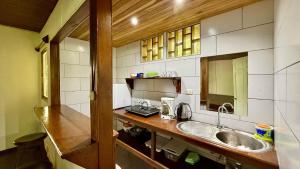 a small kitchen with a sink and a counter at El Clan Hostel in Puerto Viejo