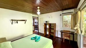 a bedroom with a bed and a table and a window at El Clan Hostel in Puerto Viejo