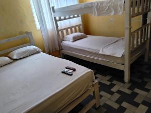 two bunk beds in a room with a remote control at hotel habiby32 descansa in Barranquilla
