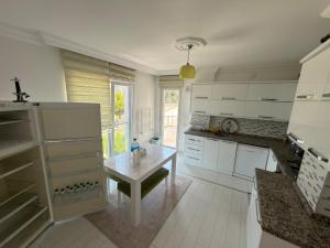 a kitchen with white cabinets and a table in it at Trabzon Panoramik Vip Hause in Trabzon
