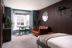 a bedroom with a bed and a chair and a table at Modern Studio Apartment with harbour views in Penzance