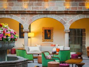 a patio with a couch and chairs and flowers at Novotel Cusco in Cusco