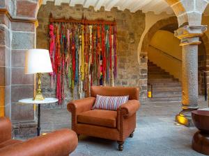 a chair and a lamp in front of a wall at Novotel Cusco in Cusco