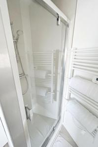 a shower with a glass door in a bathroom at Cosy appartement in Miniac-Morvan