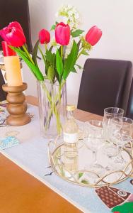 a table with a vase of flowers and a bottle of wine at Sofia's Guest House in Levkákia