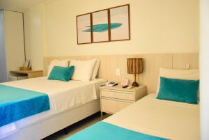 two beds in a hotel room with blue and white at Grand Lençóis Flat in Barreirinhas +32 photos