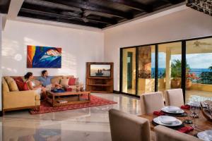 a woman sitting on a couch in a living room at Luxury Oceanview Penthouse in HDM in Punta Mita