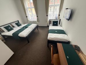 two beds in a small room with windows at U Císaře Rudolfa in Mělník