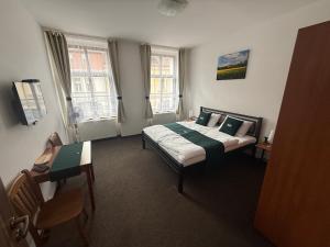 a hotel room with a bed and a desk and window at U Císaře Rudolfa in Mělník