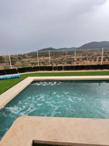 a swimming pool in front of a fence at Cueva mágica de Raspay in Raspay