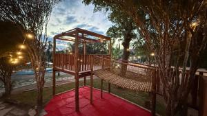 a swing set in a park with trees and lights at Ville Real Hotel in Santo Antônio do Leite +167 photos