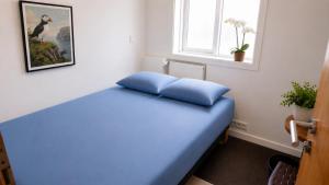 a bedroom with a blue bed with a window at 105 Guesthouse Hotel in Reykjavík