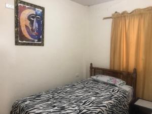 a bedroom with a bed and a painting on the wall at Suite Melón in Santa Elena