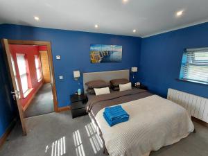a bedroom with blue walls and a large bed at Golf Style in Lisdoonvarna
