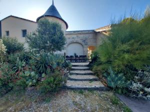a garden with a stone path leading to a building at Logis Insolites et Restaurant Domaine du Seudre in Saint-Germain-du-Seudre
