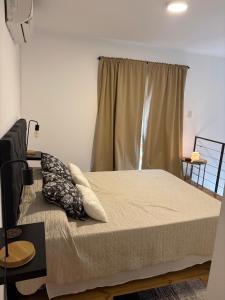 a bedroom with a bed with pillows and a window at Villa Los Cóndores in Las Chacras +16 photos