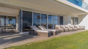 a group of chairs on a patio with a view of the ocean at Encantame Velero Ground Floor, BeachFront in Playa Encanto