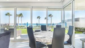 a dining room with a table and views of the ocean at Encantame Velero Ground Floor, BeachFront in Playa Encanto