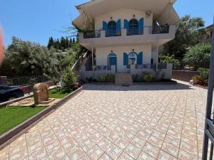 a house with a driveway in front of it at Myrovolos Guesthouse in Apolpaina