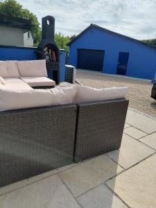 a couch sitting on a patio with a blue building at Golf Style in Lisdoonvarna