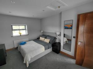 a bedroom with a bed and a window and a mirror at Golf Style in Lisdoonvarna
