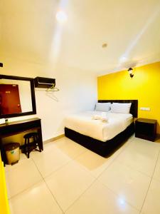 a bedroom with a bed and a desk and a television at N HIBISCUS HOTEL in Seri Kembangan