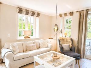 a living room with a white couch and a chair at Haus "Carla Marie" in Hedehusum