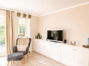 a living room with a tv and a chair at Haus "Carla Marie" in Hedehusum