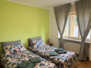a bedroom with two beds and a window at Casa Sottomonte in Venzone