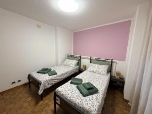 two beds in a small room with green pillows at Casa Sottomonte in Venzone +22 photos