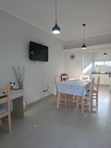 a dining room with a table and chairs and a tv at Soles de Pergamino in Pergamino