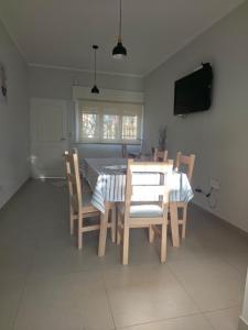 a dining room with a table and chairs and a television at Soles de Pergamino in Pergamino