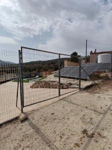 a chain link fence in front of a building at Cueva mágica de Raspay in Raspay
