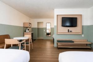 a room with a tv and a table and chairs at Stargazer Hotel in Monterey