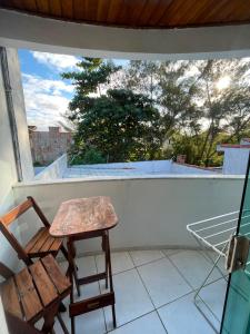 a wooden chair sitting on a balcony with a window at Casa Estelar in Cabo Frio