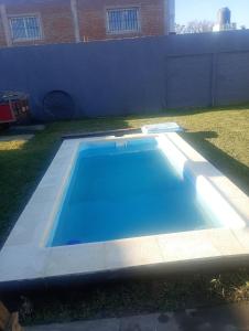 a blue swimming pool in the yard of a house at Apartamento El Rancho in San Pedro