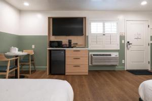 a room with a bed and a kitchen with a tv at Stargazer Hotel in Monterey