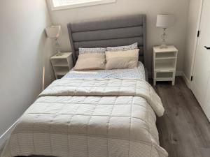a bedroom with a large bed with two night stands at Cozy Suite Near Airport in YYC
