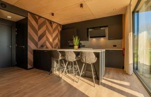 a kitchen with a counter and stools in a room at Forest Villa 8 persons #724 in Maasbree