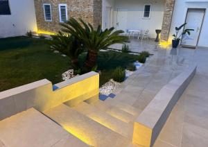 a courtyard with a bench and a palm tree at Le Dimore Airport Luxury in Bari