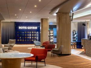 eine Hotellobby mit Stühlen und Tischen in der Unterkunft Mercure Gdynia Centrum in Gdynia