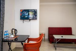 a room with a table and a chair and a tv at Kitobo Serenity Resort in Arusha +13 photos
