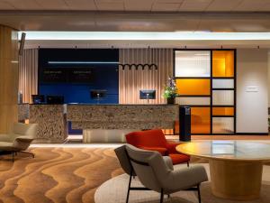 eine Lobby mit Tisch und Stühlen und einer Bar in der Unterkunft Mercure Gdynia Centrum in Gdynia