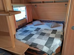 a small bedroom with a bed in the middle at Karavan u přehrady in Prostějov