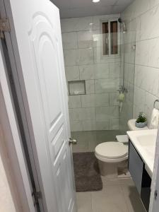 a white bathroom with a toilet and a sink at Los Alcarrizos Puente Blanco Urban Oasis ubicado en la calle 22 numero 98 los alcarrizos in Santo Domingo